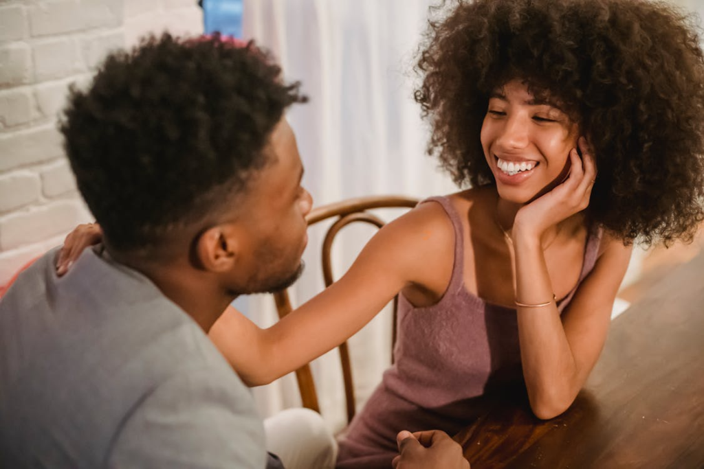 Couple sitting at table in apartment and talking