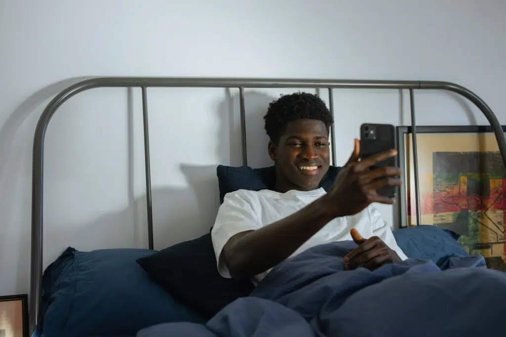Man Lying on Bed while having a Facetime Session