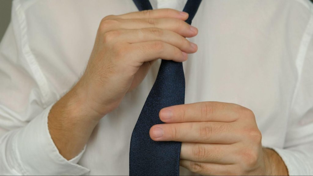 A man fixing his tie