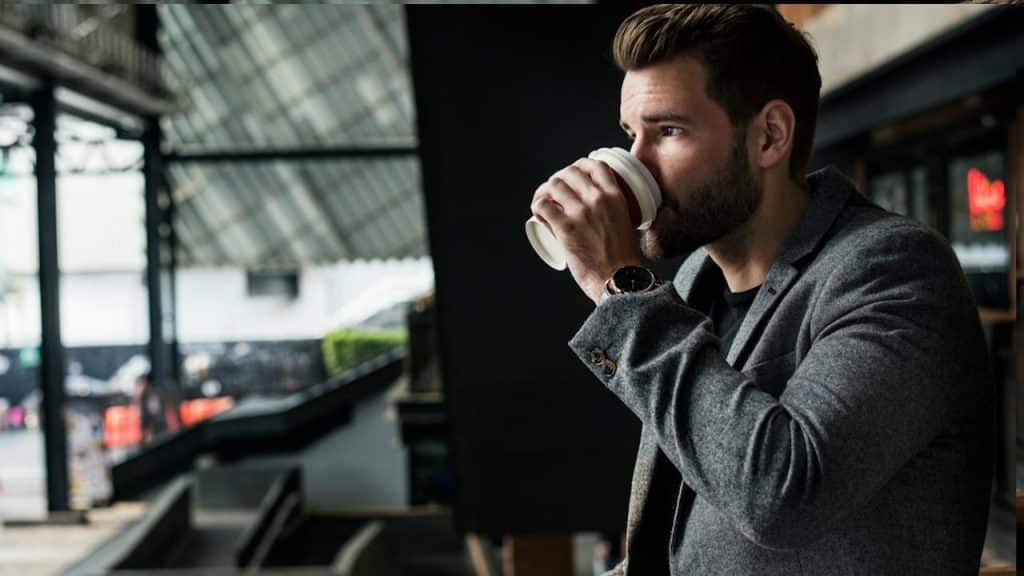 Side view of man drinking hot coffee.