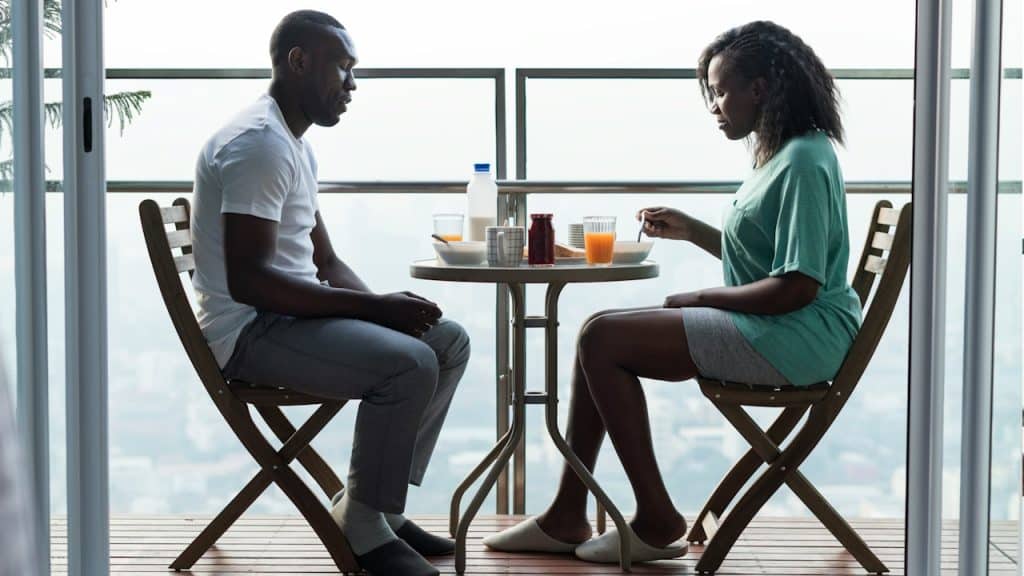A couple having breakfast while sitting quietly at a table.