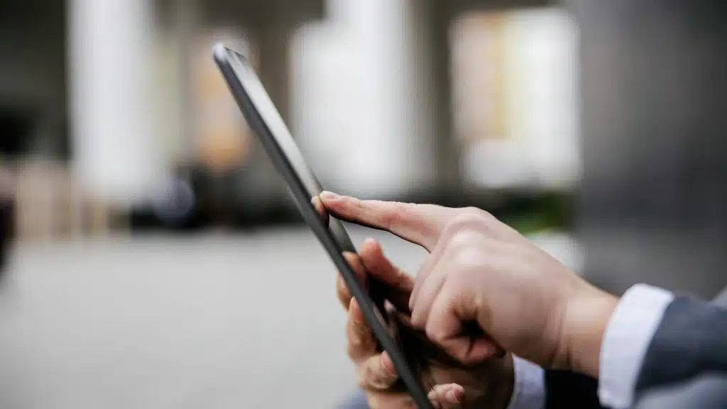 A person using a tablet outdoors.