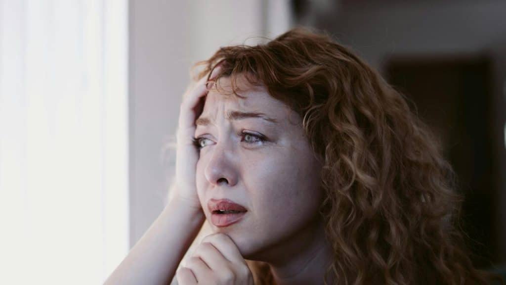 A sad woman is crying tears of grief.
