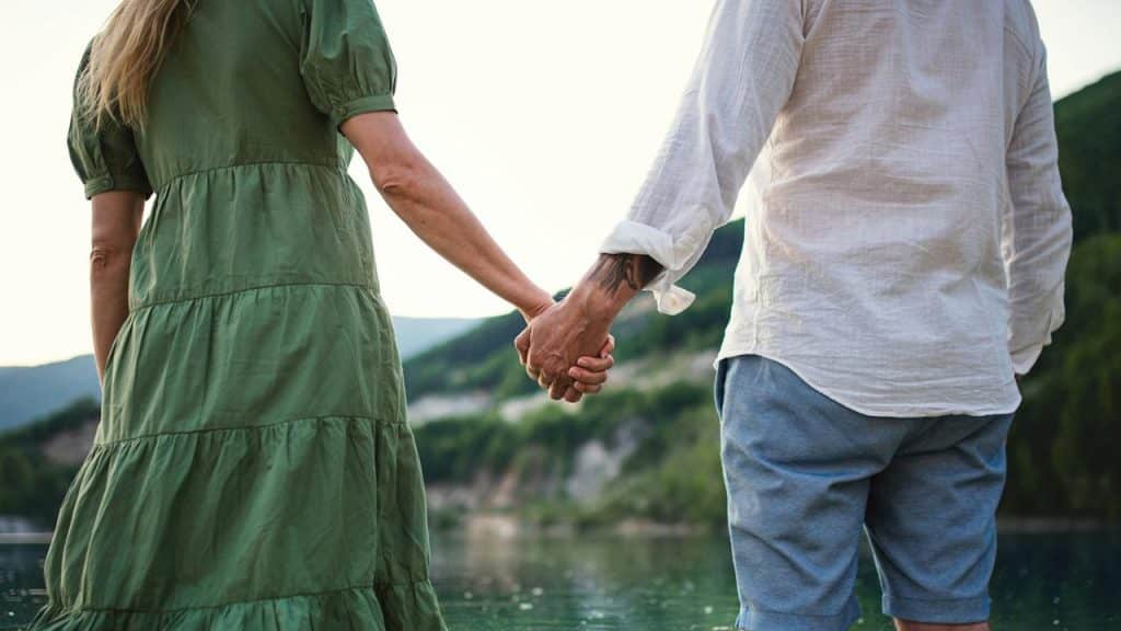 A couple standing while holding hands.