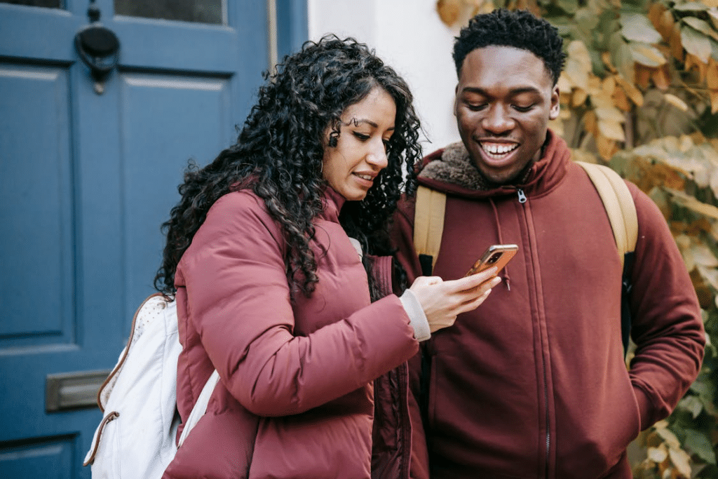 Couple smiling and checking smartphone