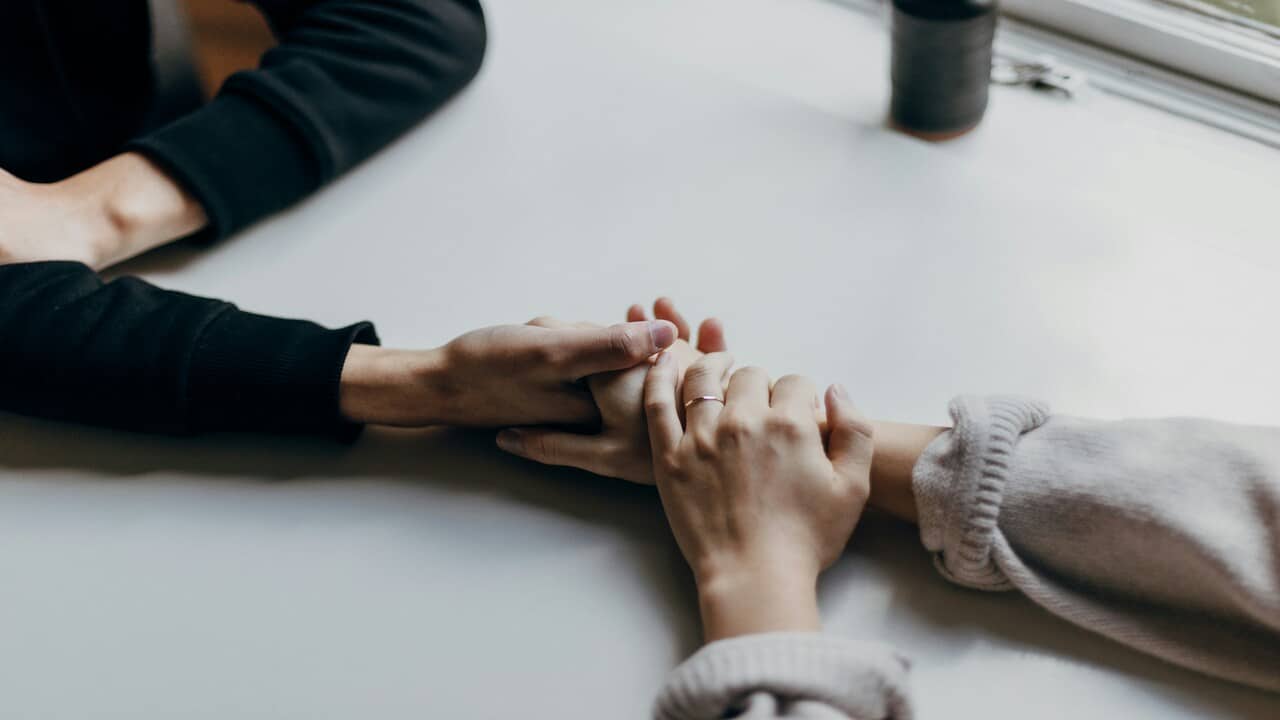A couple holding hands at a cafe