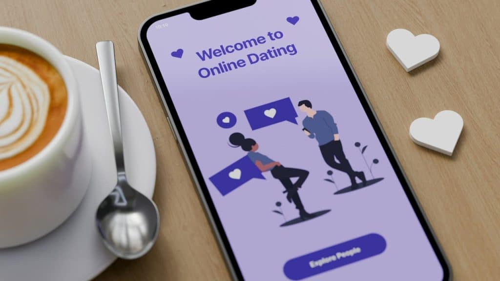 A cup of coffee is placed near a mobile phone with a dating app on its screen.