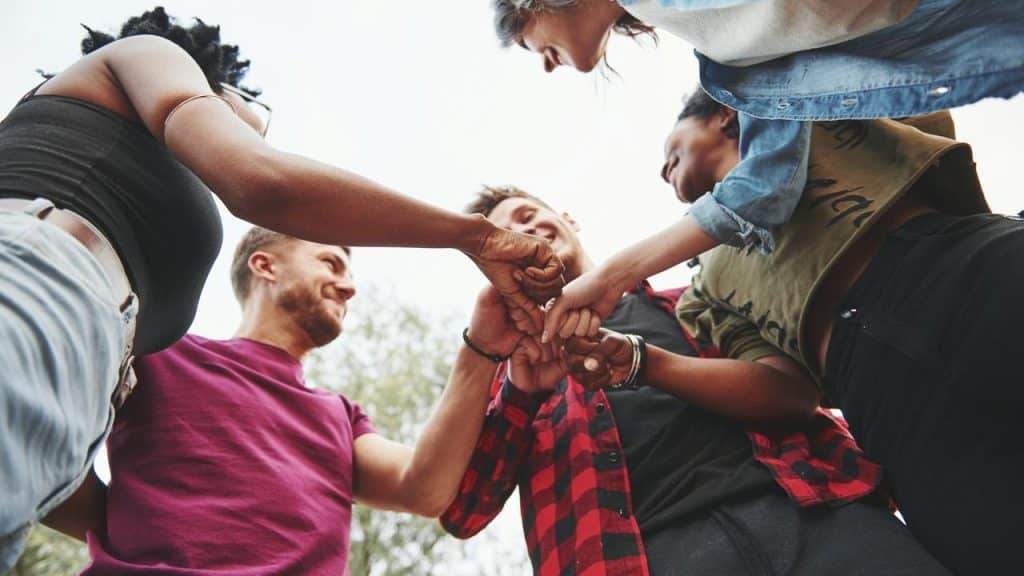 A group of friends doing a fist bump together.