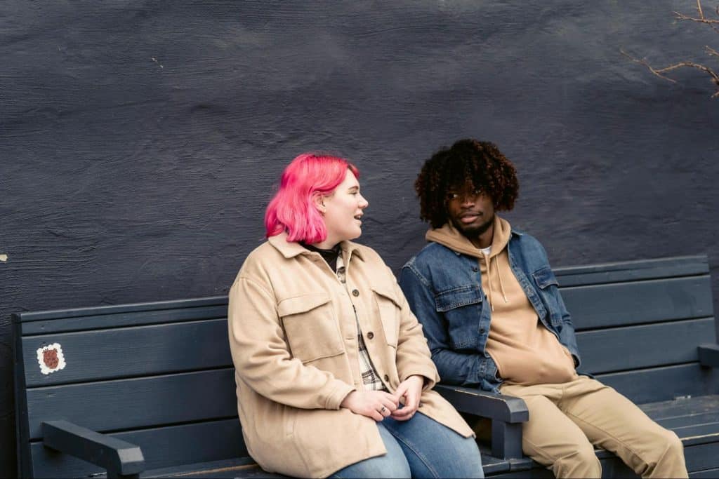 A man and woman sitting at the bench