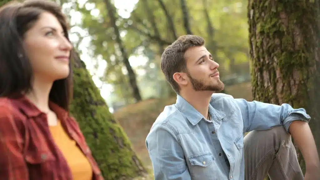 A couple relaxing together outdoors in a park.