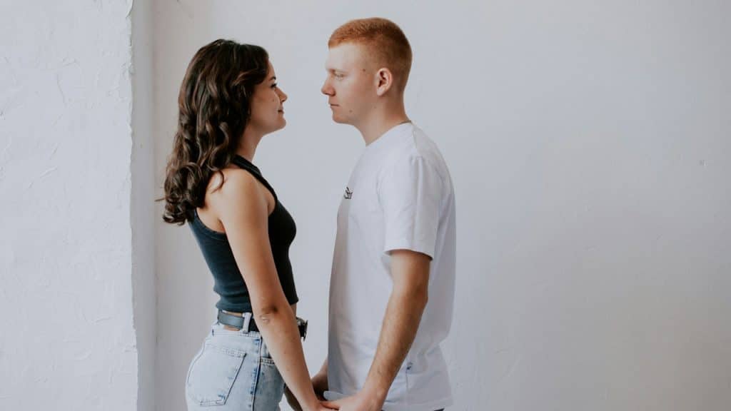 A man and a woman holding hands while standing together.