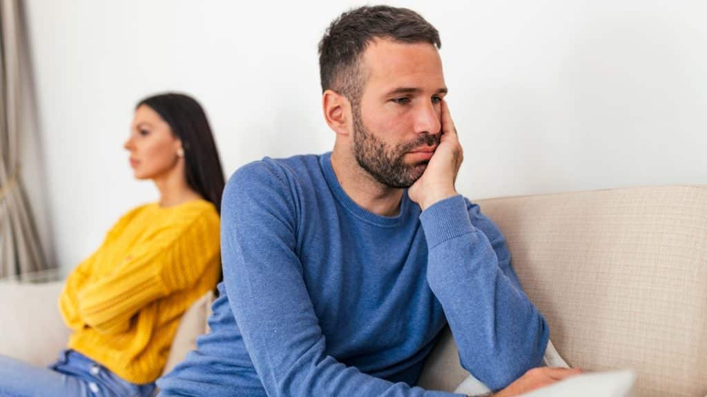 A couple sitting separately after having an argument at home.