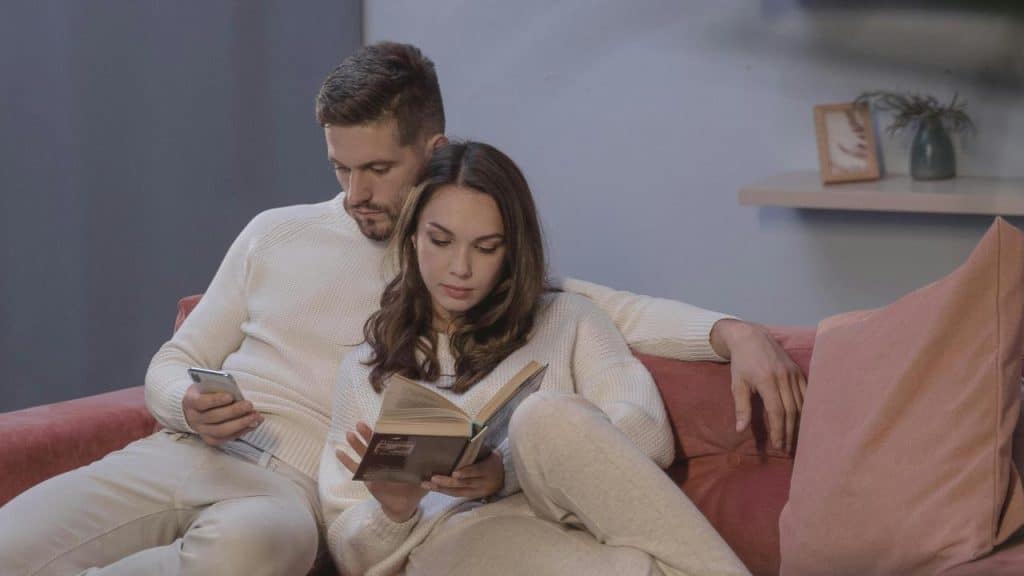 A couple sits on a couch