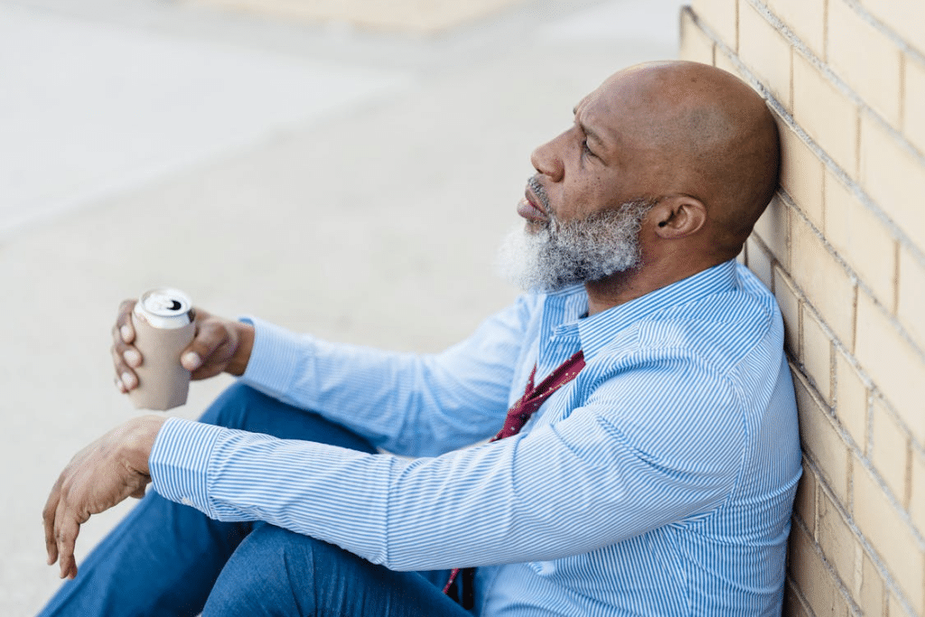 Depressed male leaning on brick wall