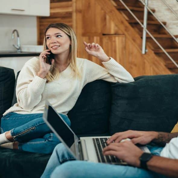 A couple using their devices at home