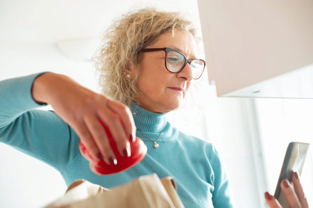 Pensive mature woman looking at phone