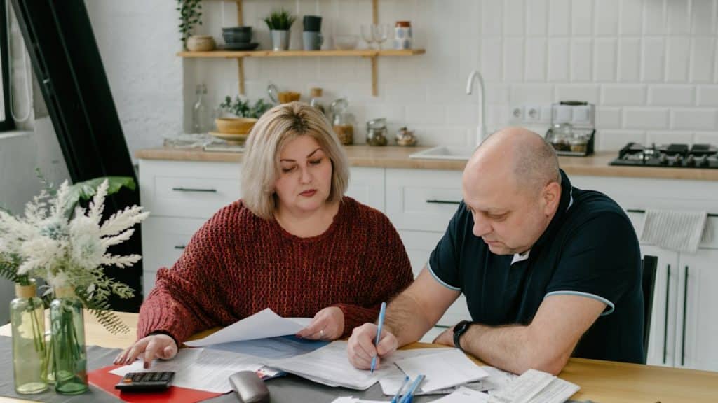 A couple making budget while sitting on the kitchen table.