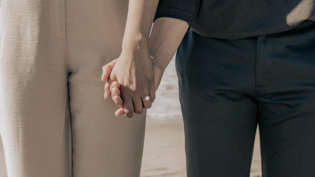 A couple holding hands outdoors.