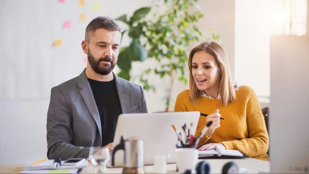 A man busy with his work and a woman tries to talk to him
