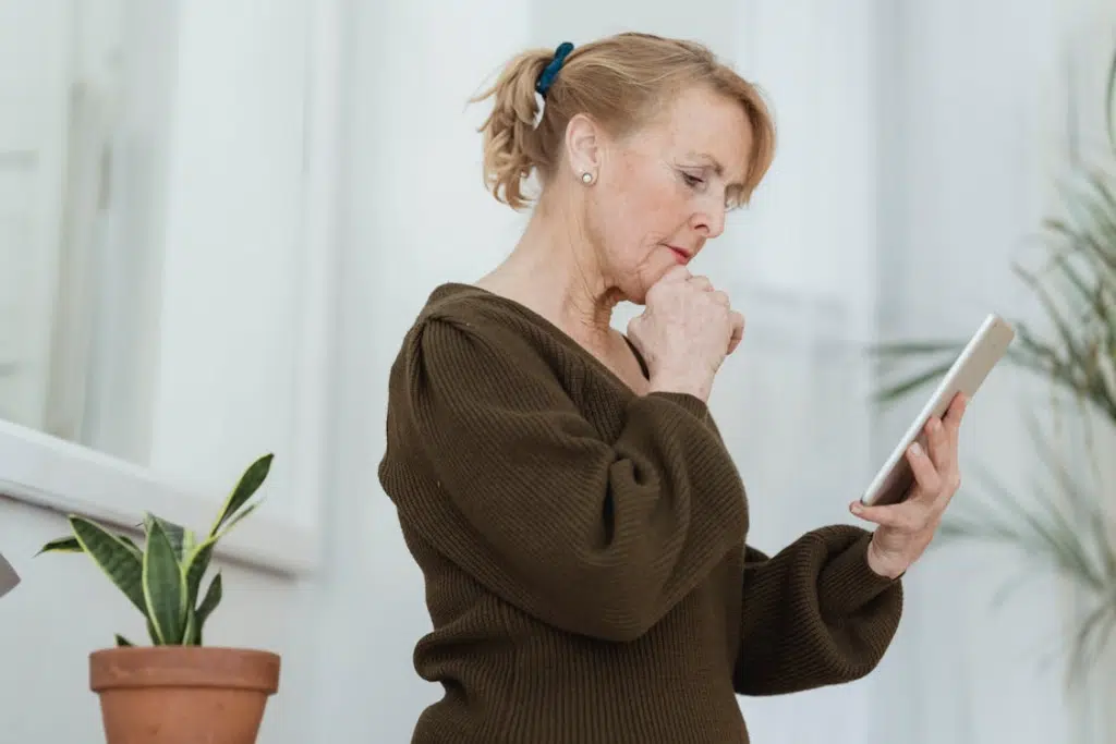 Mature woman contemplative using phone