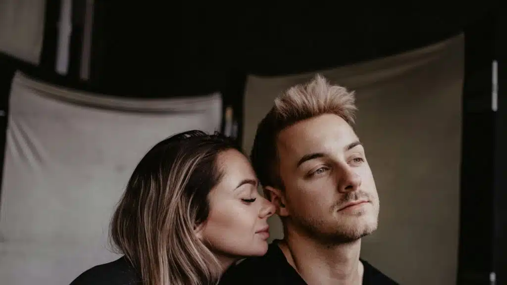 A woman putting her face on the shoulders of a man.