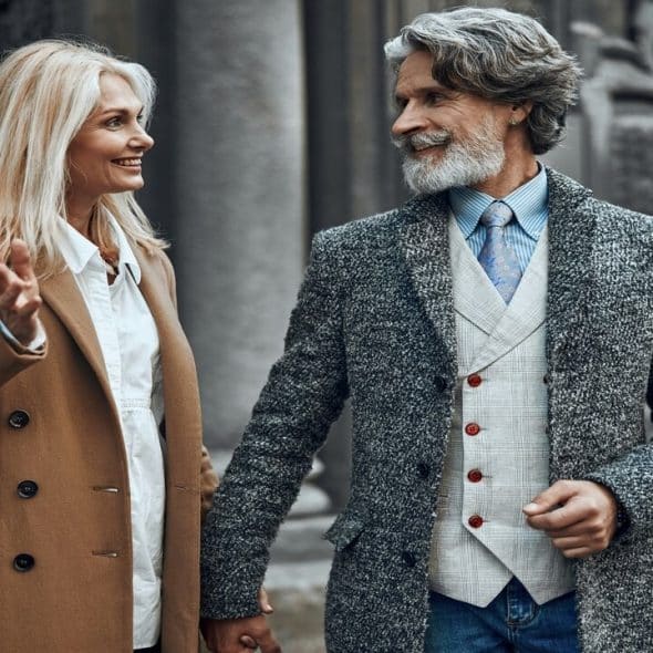 A mature couple holding hands outdoors