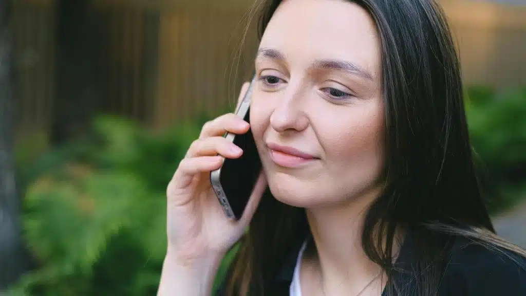 A woman talking on a smartphone outdoors.