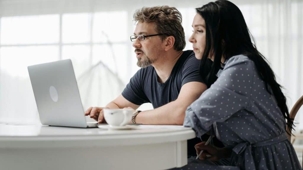 A man and woman focused on a laptop while sitting at a table with a cup of coffee.Early on, you'd soften things. Avoid saying what really needed to be said because you didn't want to hurt their feelings or start a fight. But years in, you've both realized that tiptoeing around the truth creates more damage than telling it outright.