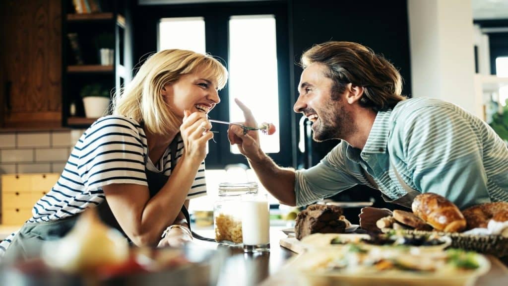 A couple laughing together in the kitchen