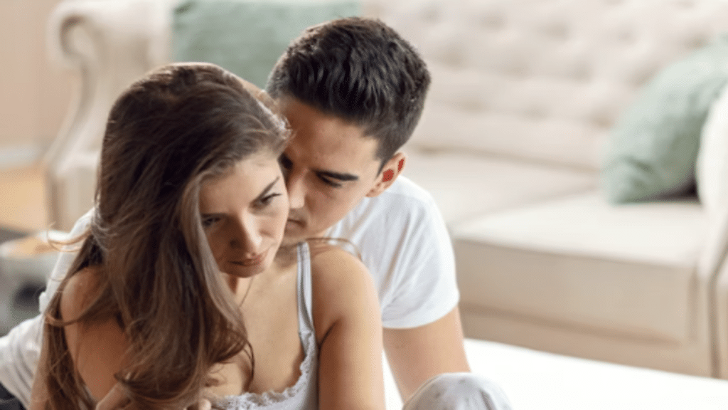 A woman looking sad while her husband hugs her