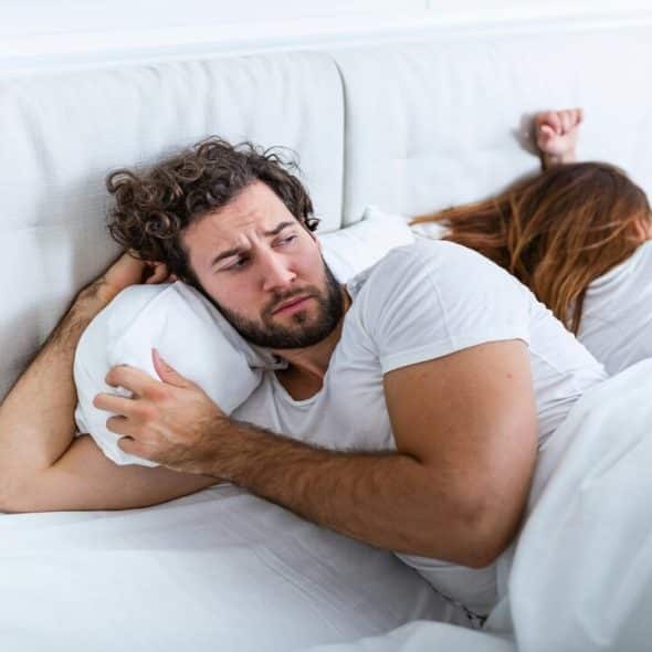 A man looking warily at his wife before sleeping
