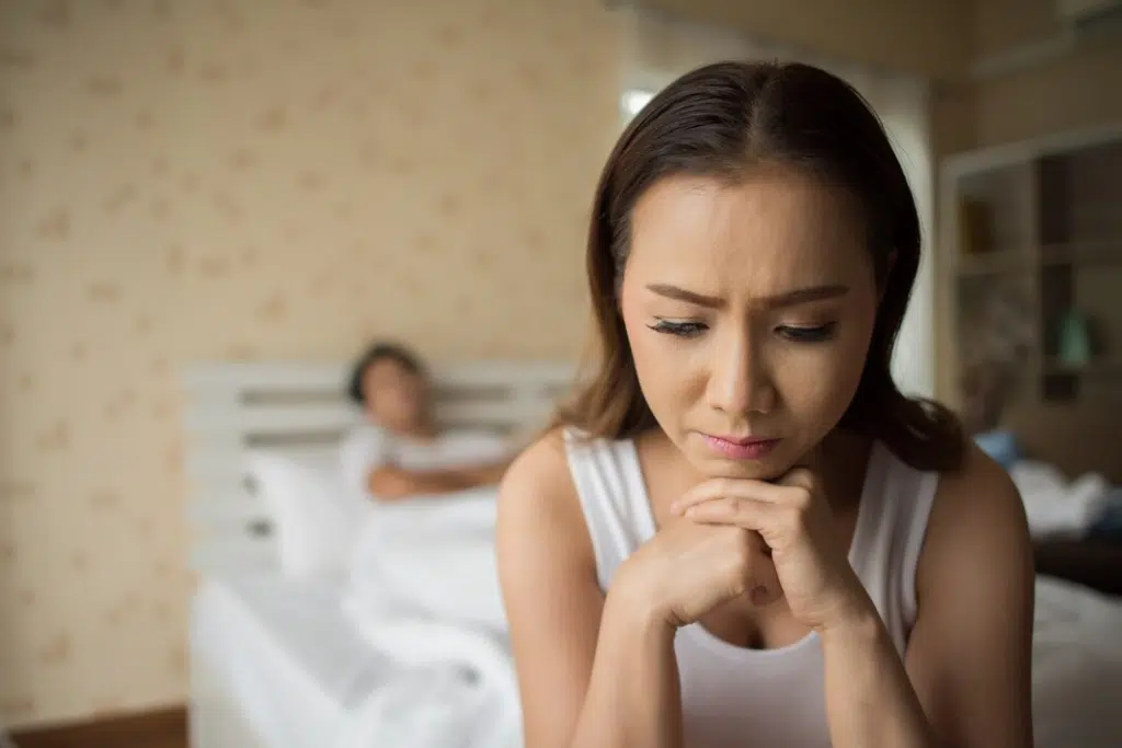 Sad woman and angry her boyfriend on the bed