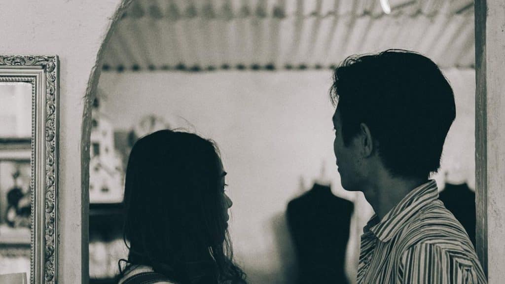 A man and a woman standing in grayscale photography.