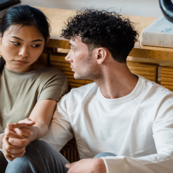 A couple having a serious talk on the floor