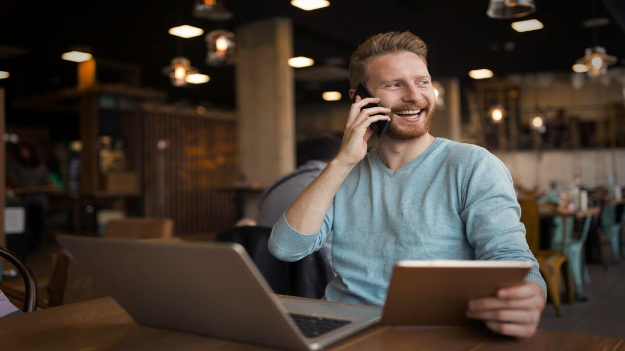 A man laughing at a coffee shop