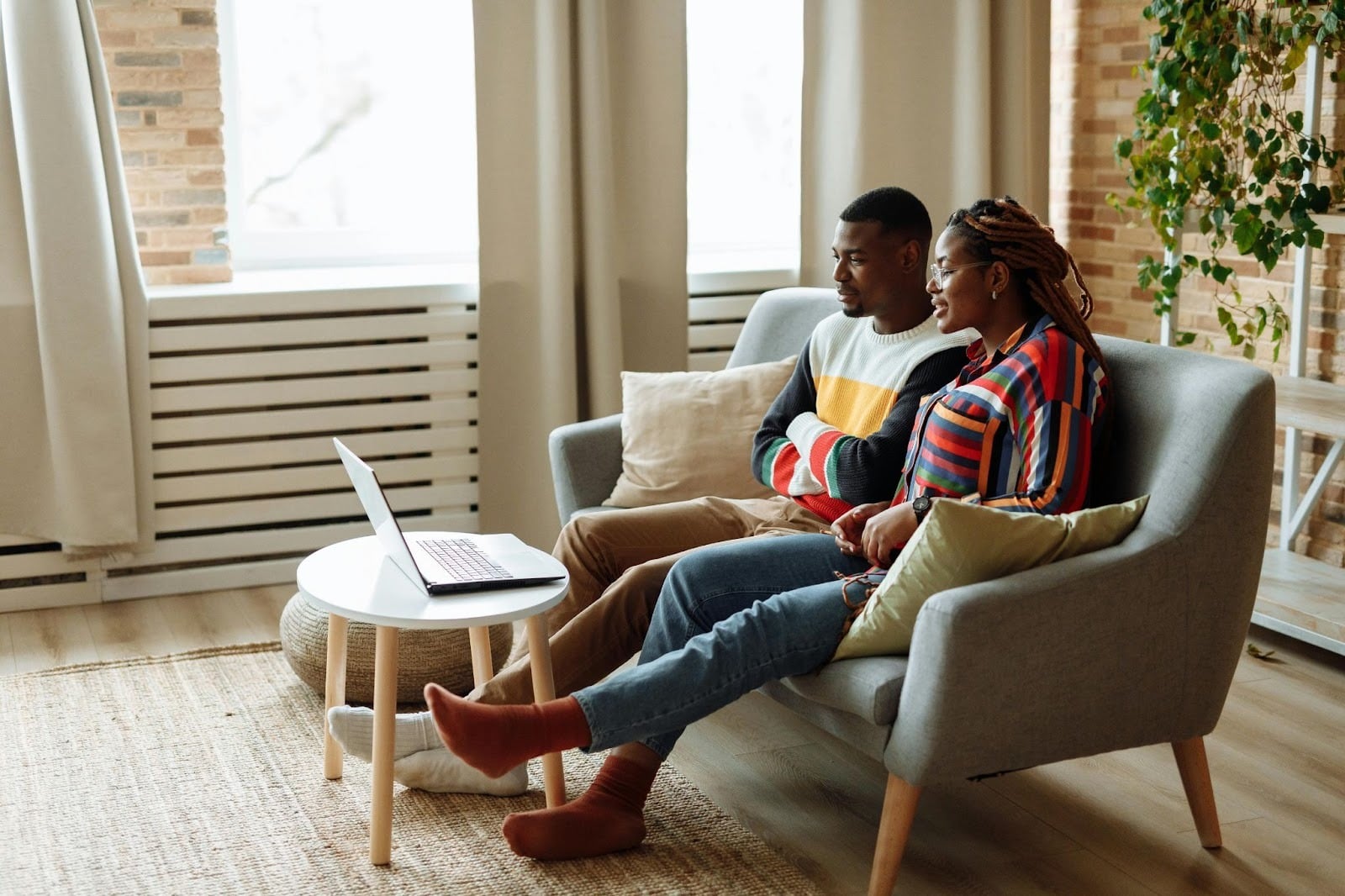 A man and woman watching on laptop