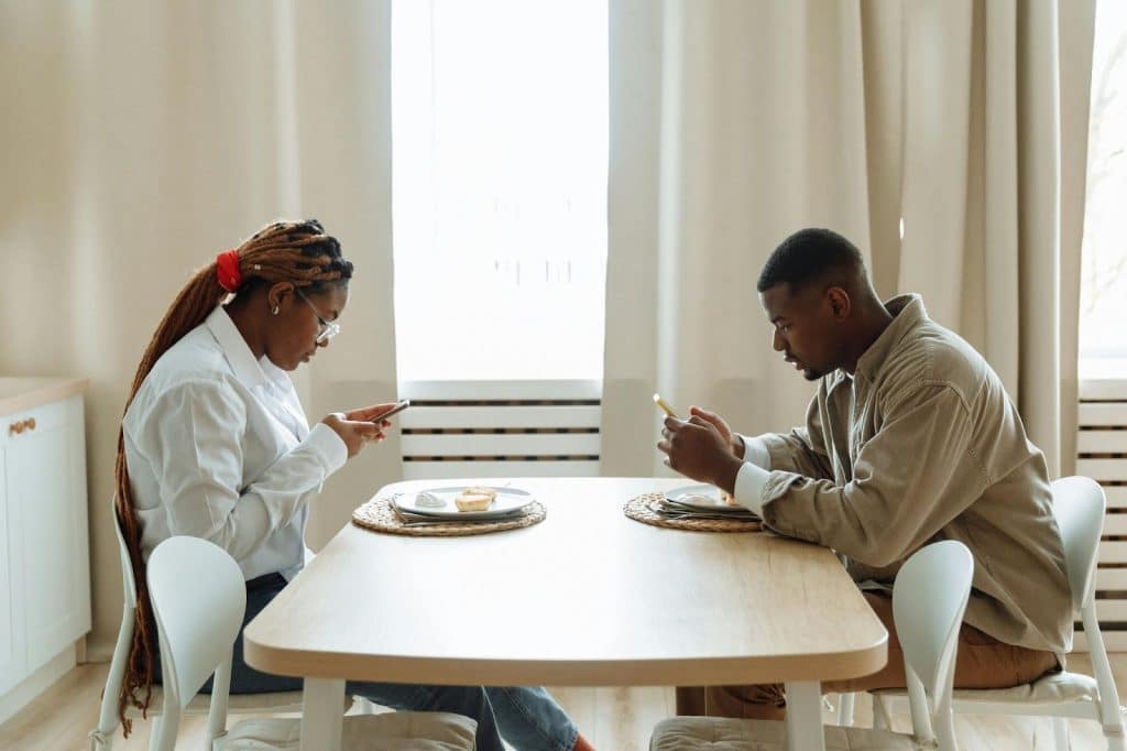 A man and woman busy with their phone