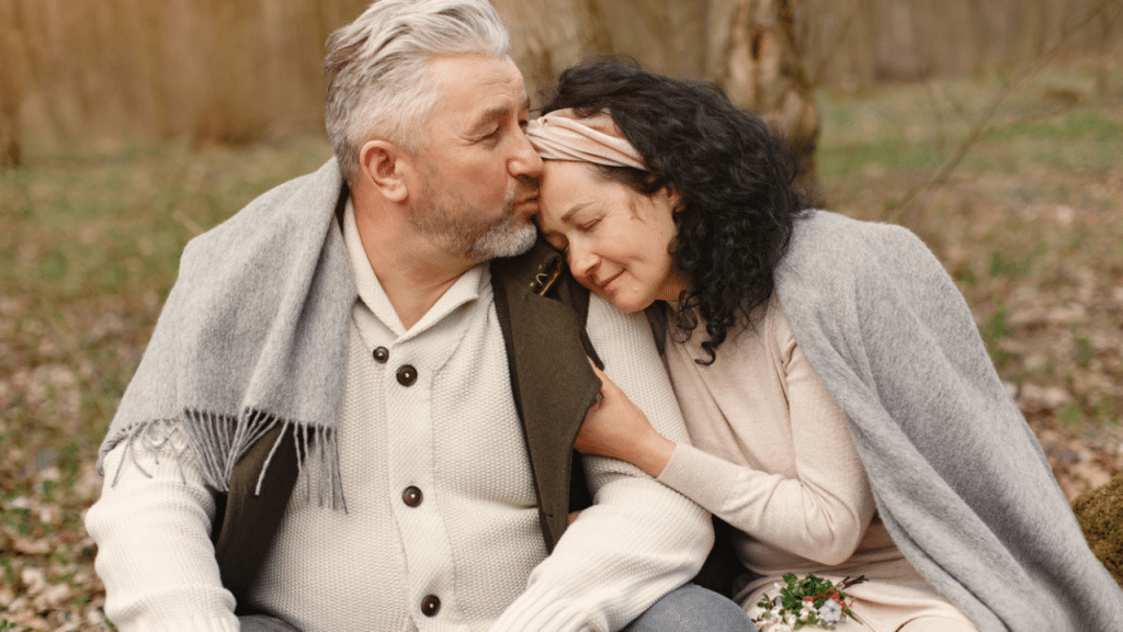 A man giving his wife a forehead kiss