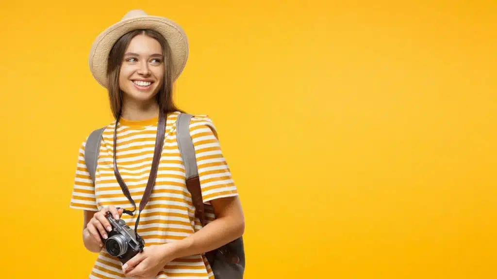 A woman holding a camera is posing for a picture.