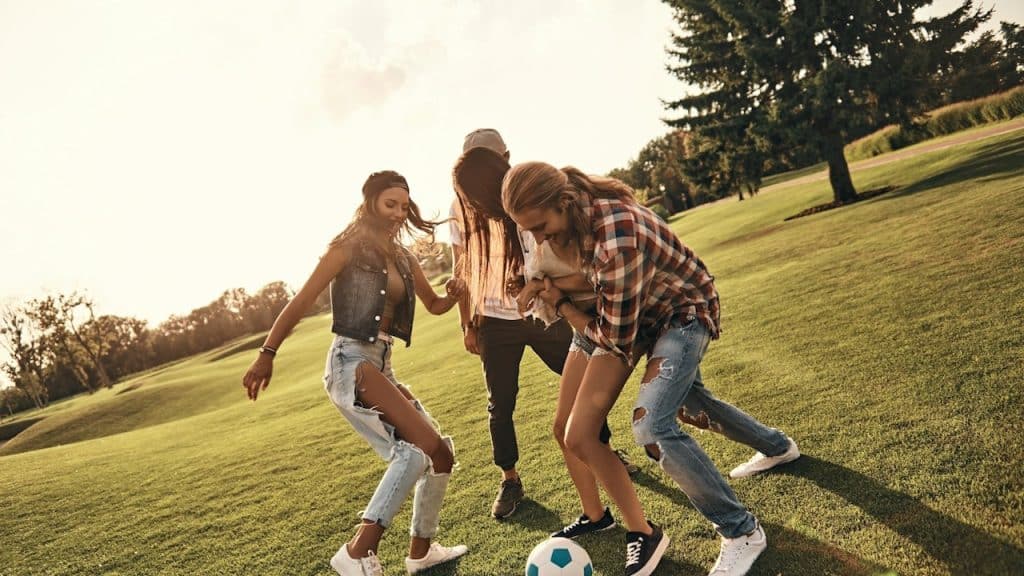 A group of women playing football on a ground.
