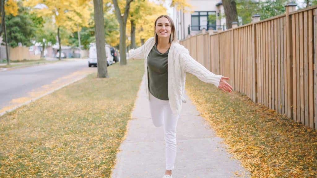 A woman posing for picture in autumn trees.
