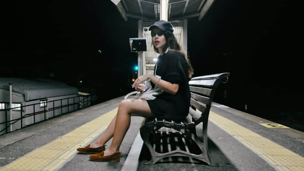 A woman sitting on a bench on a metro station.