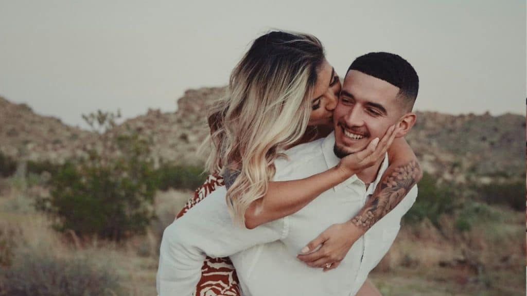 A man and a woman hugging in the desert.