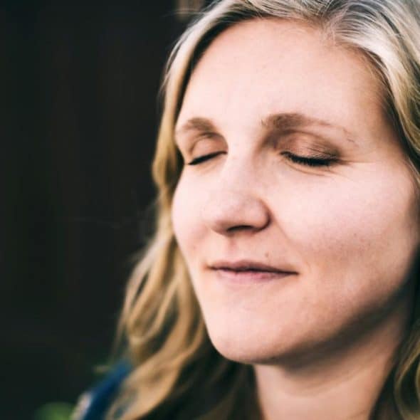 A mature woman with her eyes closed.