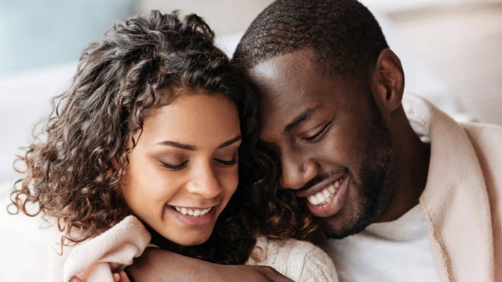 A woman snuggling with a man.