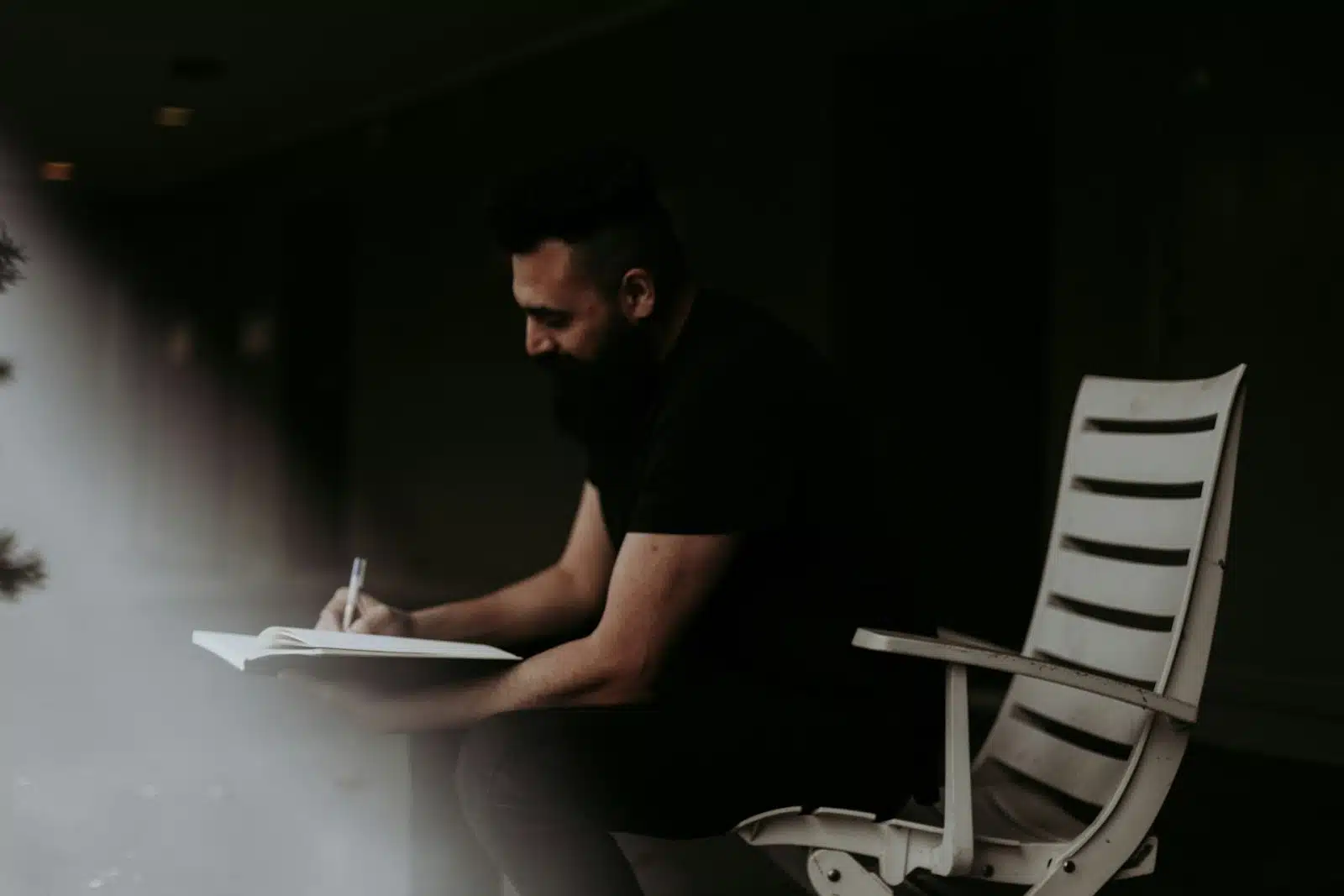 man writing notebook