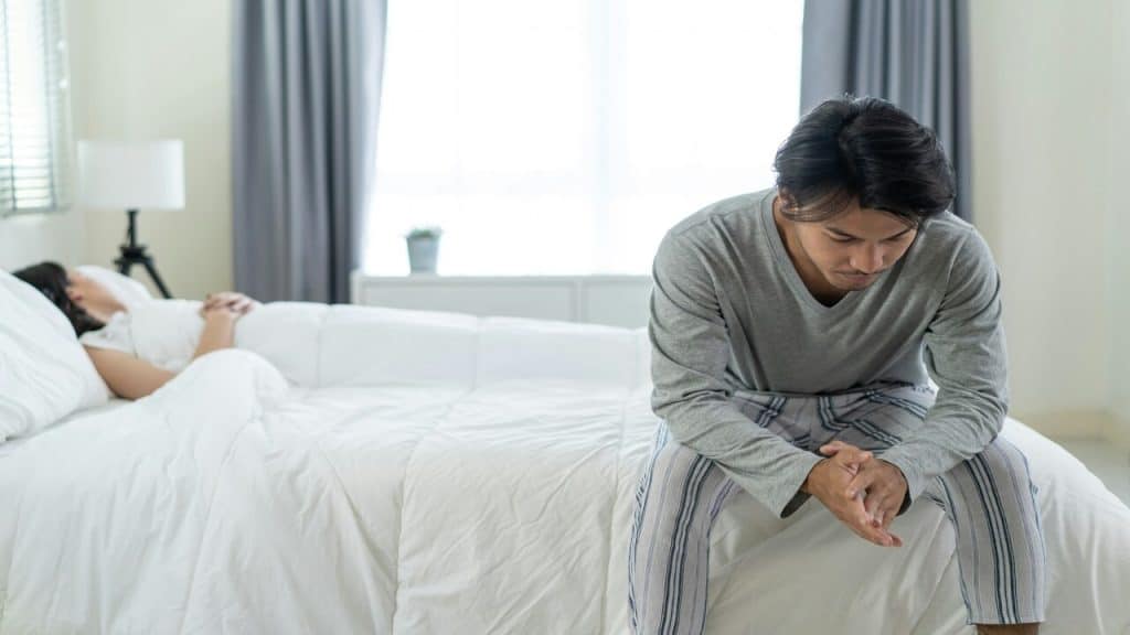 A couple looking sad in the bedroom