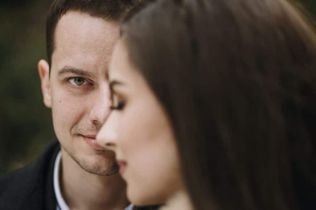 A man smiling while a woman smiles in the foreground.