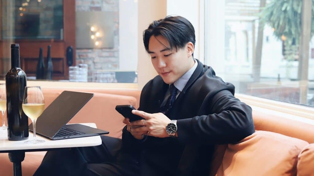A man sitting on a couch using a cell phone.