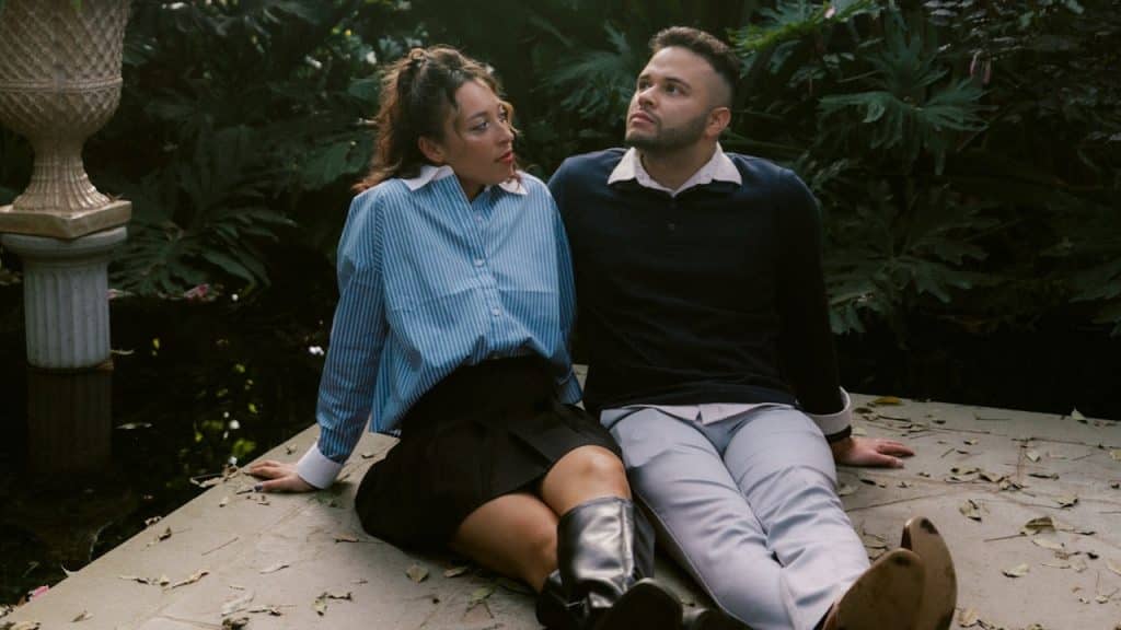 A couple sitting in a lush botanical garden.